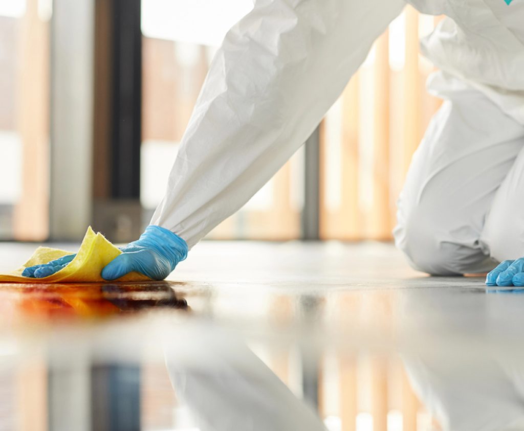 Cleanup crew for biohazard cleaning services cleaning floor in Anaheim, CA